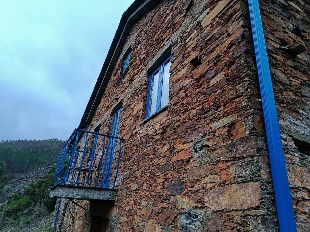 a brick building with a balcony on the side of it at Casa do Padrinho in Teixeira de Baixo