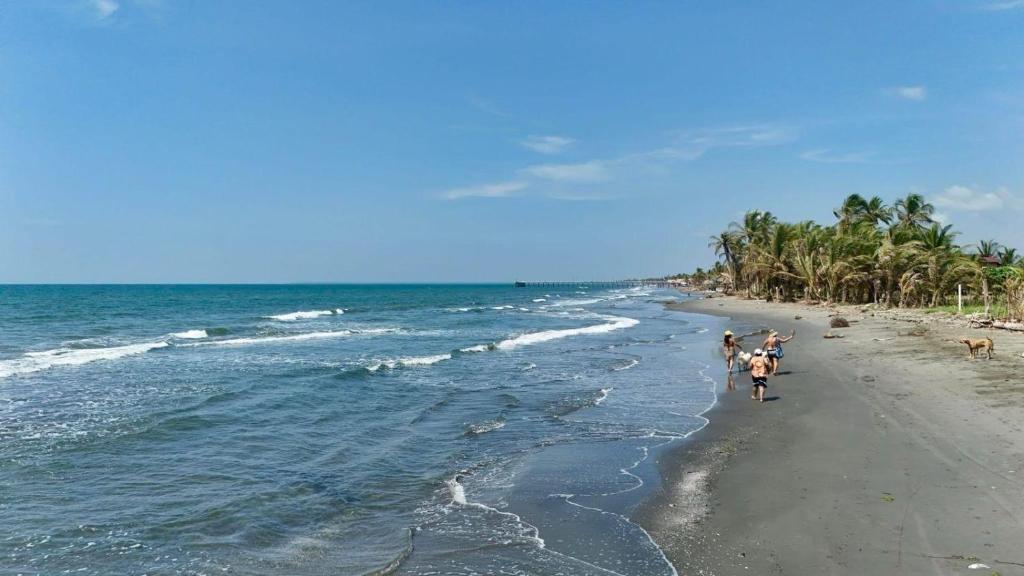 a group of people walking on the beach at Cabaña Olas del Viento 1 in San Bernardo del Viento