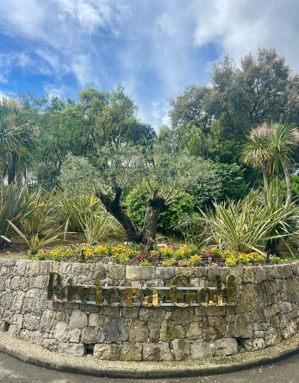 a retaining wall with a sign in a garden at French Riviera Golf in Mandelieu-La Napoule