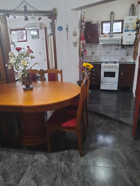 a kitchen with a wooden table with chairs and a stove at Elba Cabañas in Villa Carlos Paz