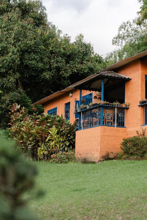 a house with a balcony on the side of it at Finca Romelia Orchids and Birds in Manizales