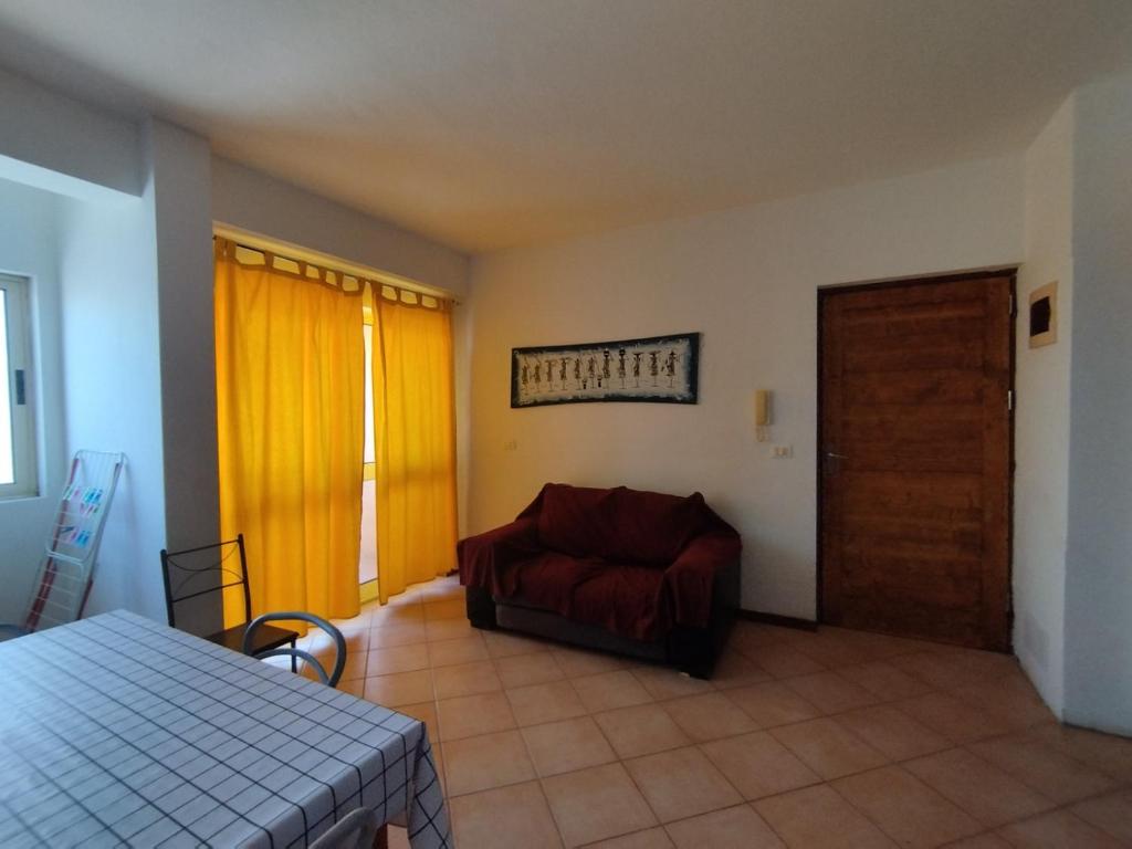 a living room with a red couch and a door at Ca Gabbiano 6 in Santa Maria