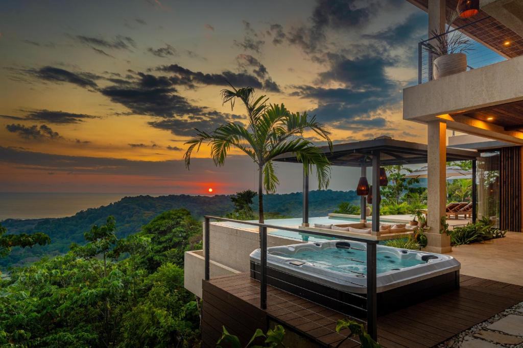 a house with a hot tub on a balcony with a view at Casa Riverstone in Dominical