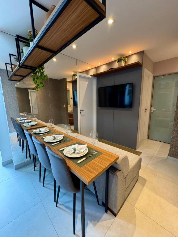 a long dining room with a long table and chairs at Infinity 1302 - Piscina, Academia e Praia a Poucos Passos in Vila Velha