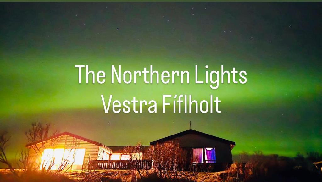 an image of a house with the northern lights at Vestra-Fíflholt cabin 1 in Hvolsvöllur