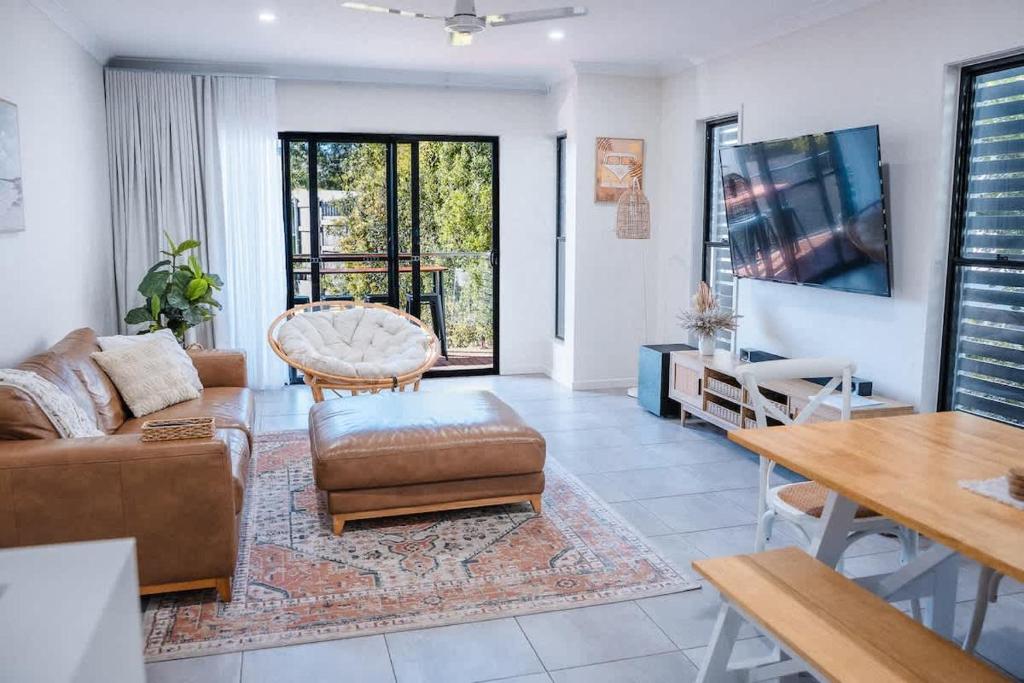 a living room with a couch and a table at The Shell Shack on Whisper Bay in Cannonvale