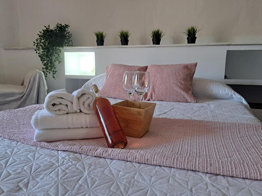 a bed with towels and a glass of wine on it at Casa cubo in Alhama de Granada