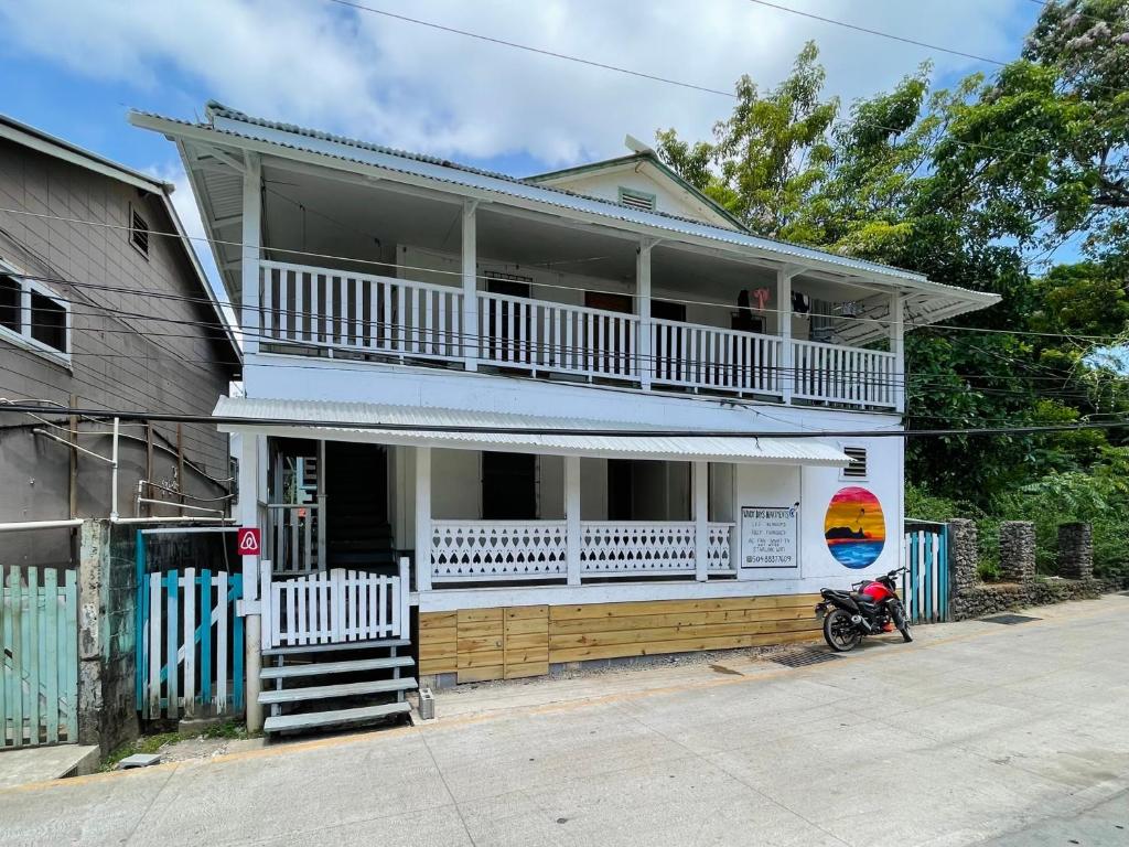 a house with a motorcycle parked in front of it at Windy days Apartments in Utila
