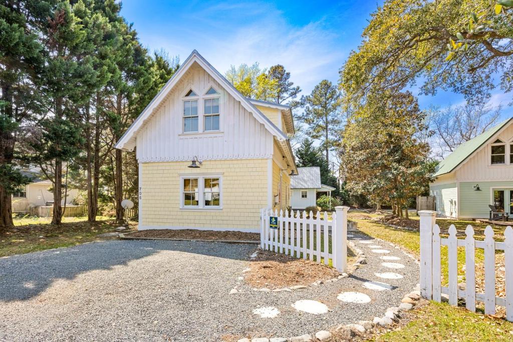 a white fence in front of a house at IC2 - Endless Summer Cottage in Manteo