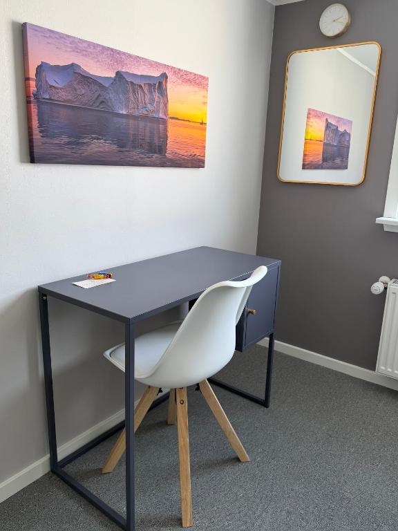 a blue desk with a white chair in a room at Møller Guesthouse in Ilulissat