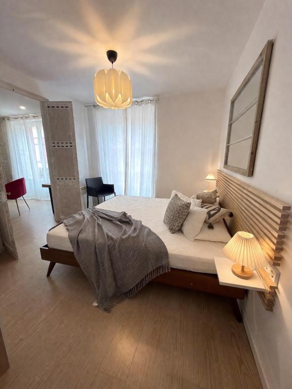 a bedroom with a large bed and a chandelier at 31CaL QuEROL Boutique centre Puigcerdà in Puigcerdà