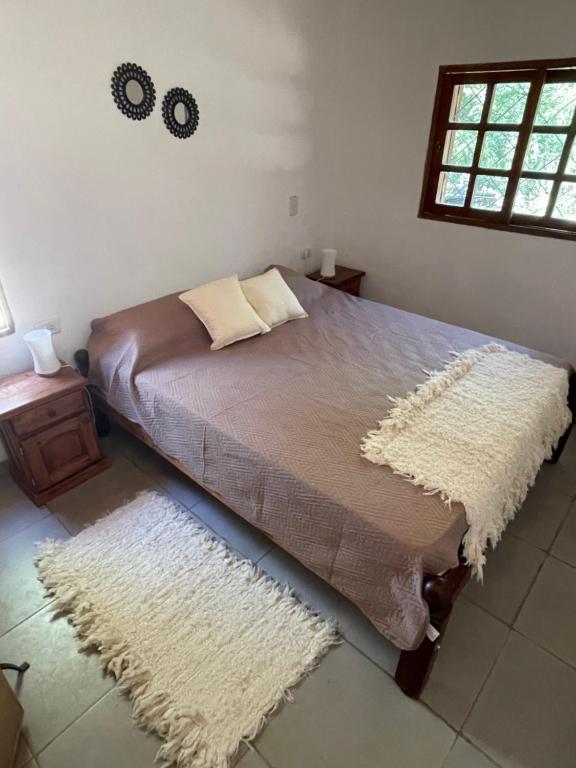a bedroom with a bed with a rug on it at Cabaña Lazarillo in Amaicha del Valle