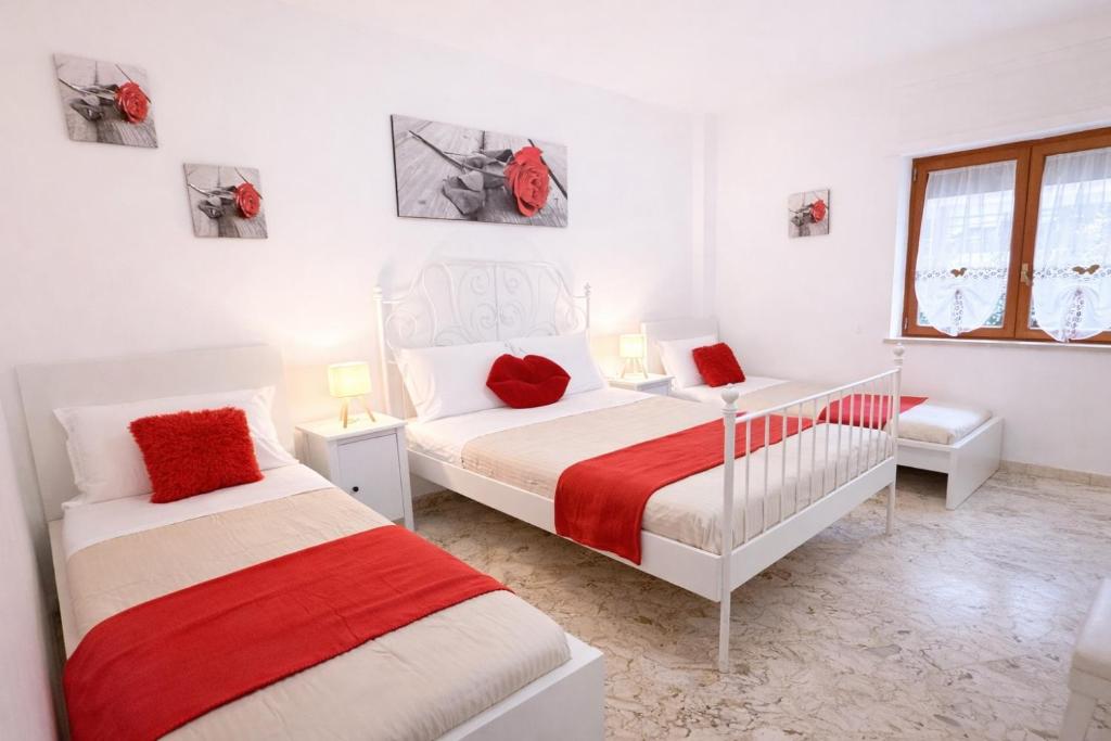 a white bedroom with two beds and a window at Casa Sant'Antonio in Bari