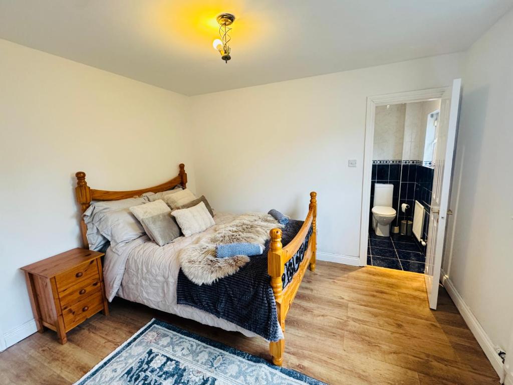 a bedroom with a bed and a bathroom at The King's Imperial Suite in Drogheda