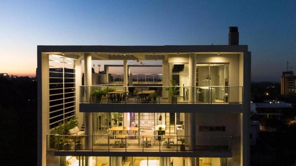 ein Gebäude mit einem Balkon mit Tischen und Stühlen in der Unterkunft Solara Hotel Boutique in Asunción