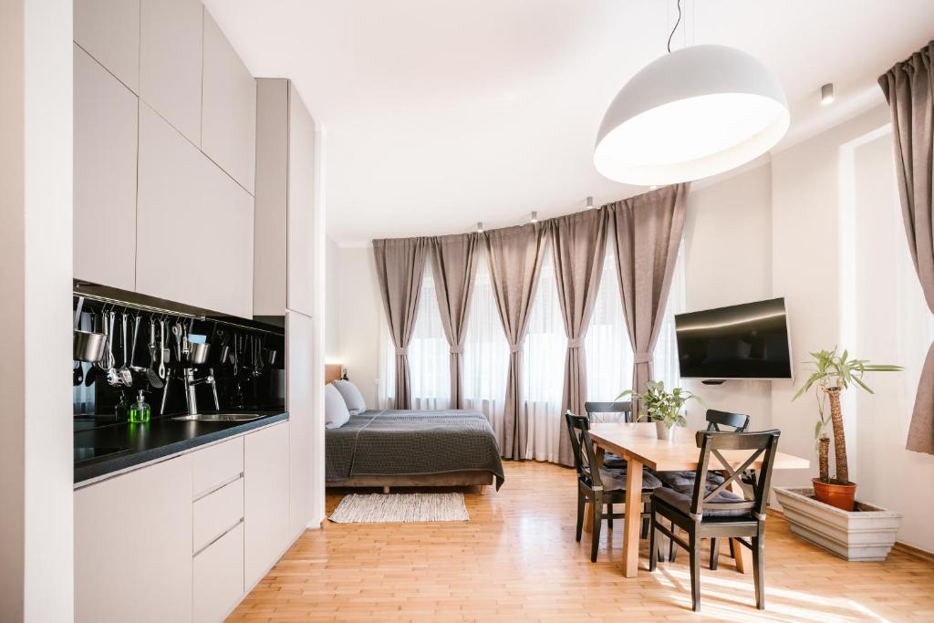 a kitchen and dining room with a table and a bed at Karlo Main Square Apartments in Zagreb