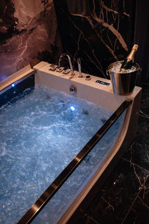 a bath tub with a bottle of champagne in it at Paradise Room - Spa & Sauna de Luxe à Yutz in Basse-Yutz