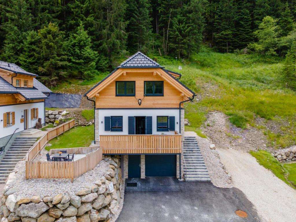 a large wooden house with a porch and a driveway at Edelweiss Lodge in Donnersbachwald