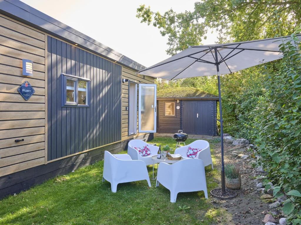 a patio with a table and chairs and an umbrella at Sunseeker in Goedereede