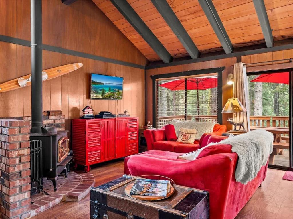 a living room with red furniture and a fireplace at 1st Cabin in Homewood