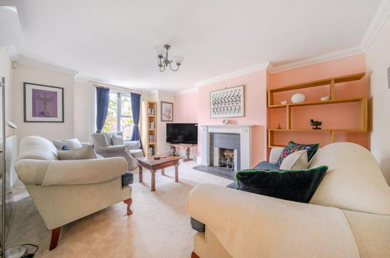 a living room with two couches and a fireplace at Charming Garden Flat in Kent