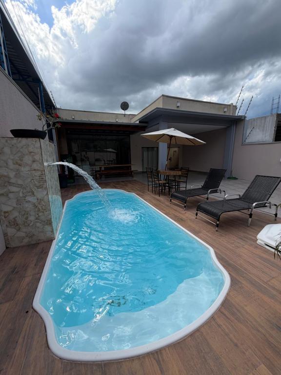 a large swimming pool with a water fountain at casa conforto e piscina in Sinop