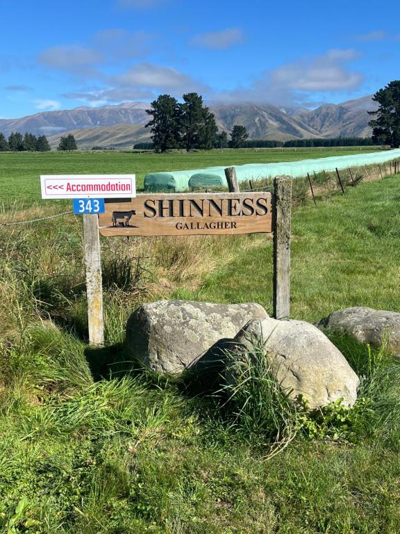 ein Schild auf einem Feld mit einigen Steinen in der Unterkunft Shinness in Ashwick Flat