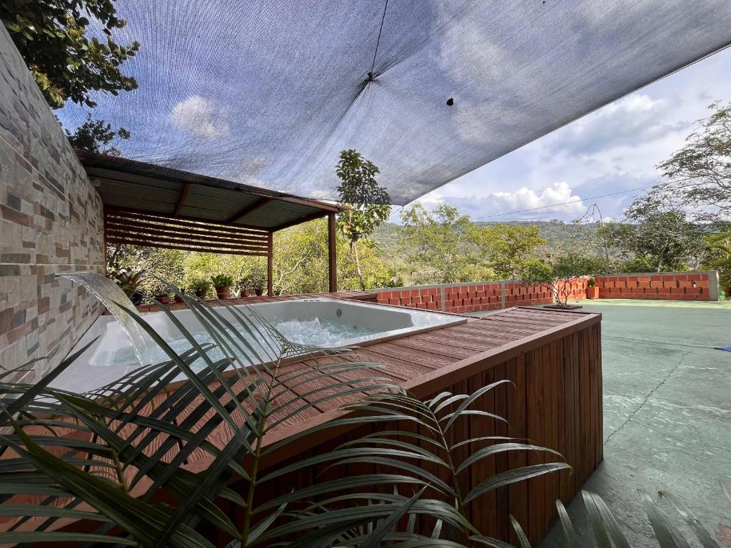 a hot tub on a deck with a roof at Hospedaje Campestre Villa Niny in San Gil