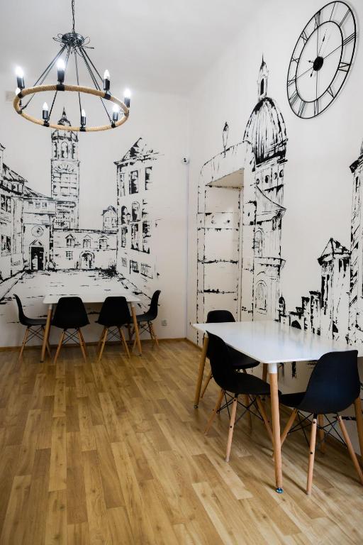 a dining room with a table and chairs and a clock at FiveHostel in Krakow