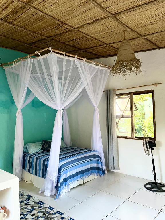 a bedroom with a bed with a canopy at Jambalau House in Lopes