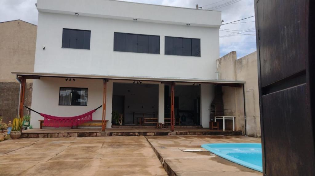 a white house with a pool in front of it at Área de Lazer Portal da Canastra in Delfinópolis