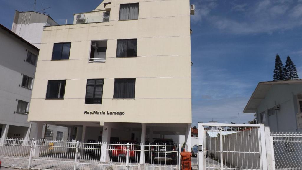 un edificio blanco con una valla delante en Apartamento Verão Canasvieiras, en Florianópolis