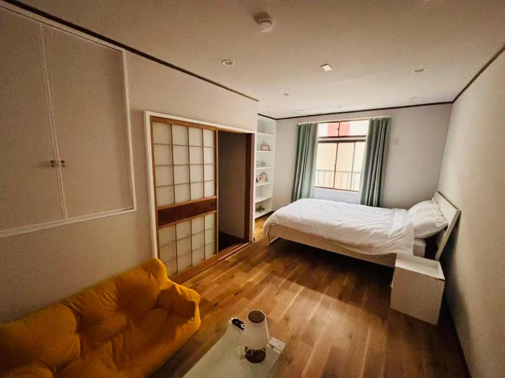 a bedroom with a bed and a couch in it at 一休居 in Osaka