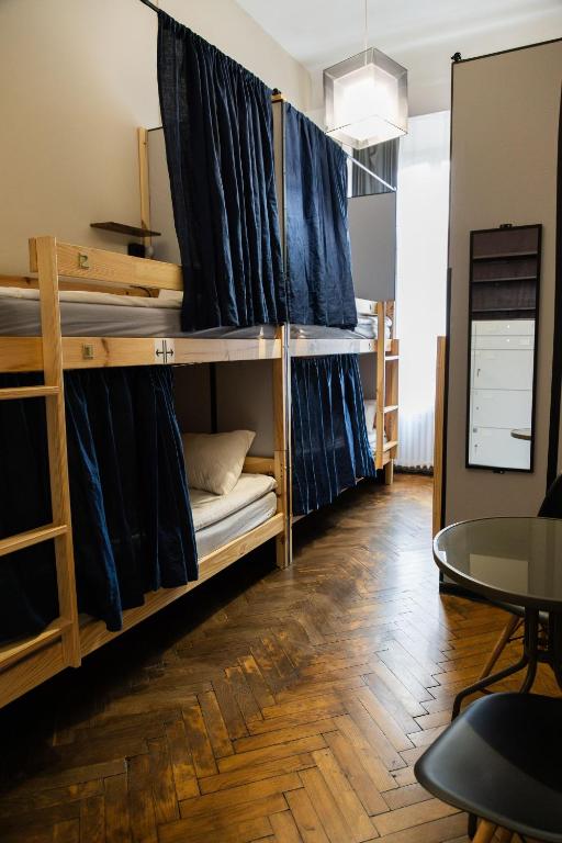a room with two bunk beds with a table and a table at Fivehostel in Krakow