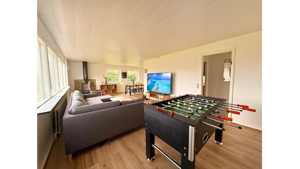 a living room with a foosball table in the middle at 4 Bedrooms Cozy & Spacious Villa - Lalandia & Puttagrden & Femern in Rødby