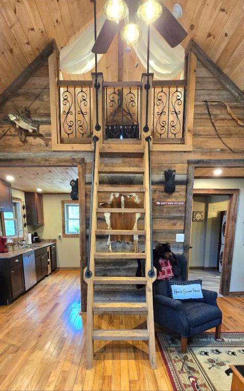 a loft bed in a room with a ceiling at Couples Getaway Cabin with a Loft Bed - Firepit - Creek Access in Dahlonega