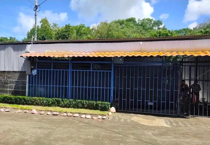 a building with a blue gate in front of it at Casa de playa MC in Quepos