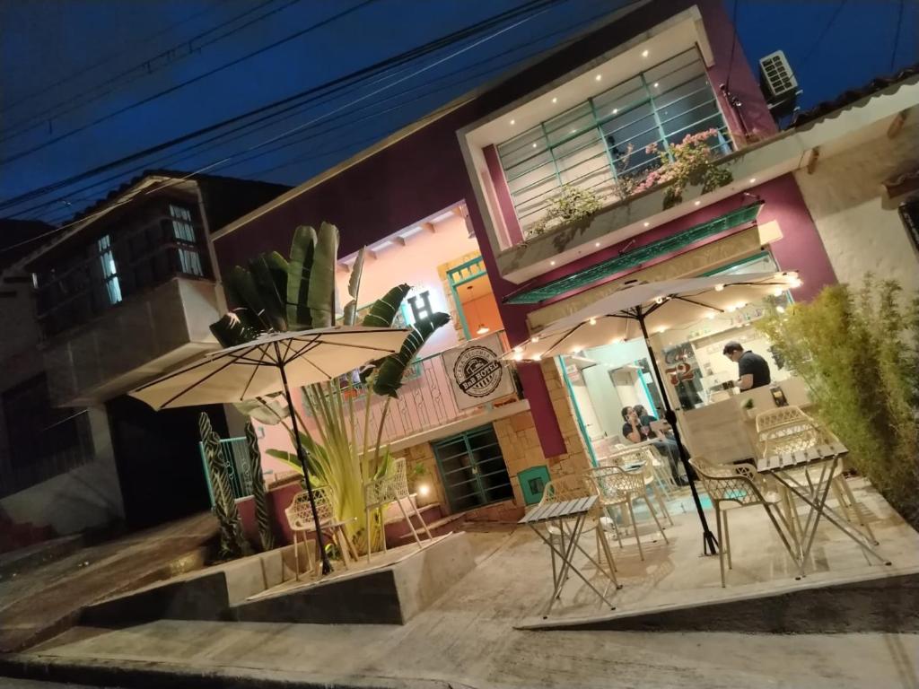 two tables and umbrellas in front of a building at HOTEL BOUTIQUE CASA VECCHIA Cali in Cali