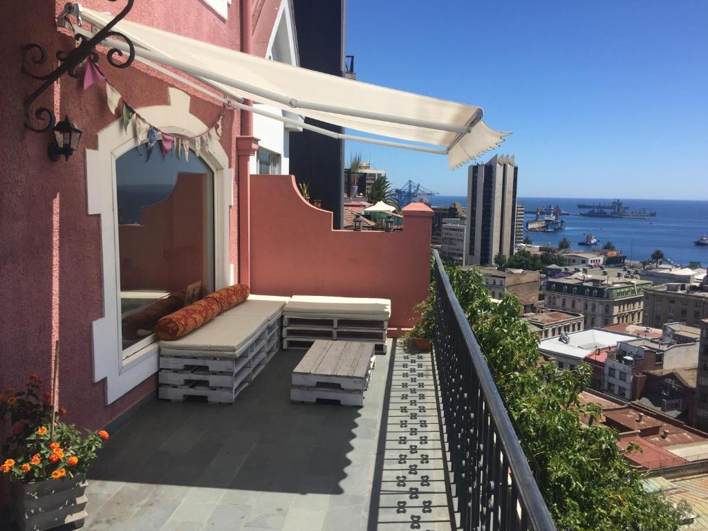 a balcony with a bench and a view of the ocean at Casona Valpo in Valparaíso