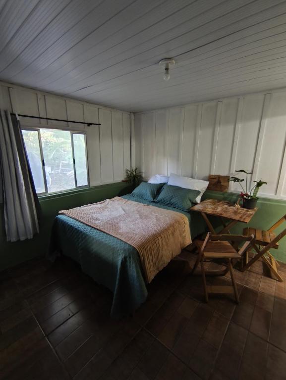 a bedroom with a bed and a table in it at Canto da restinga in Paranaguá
