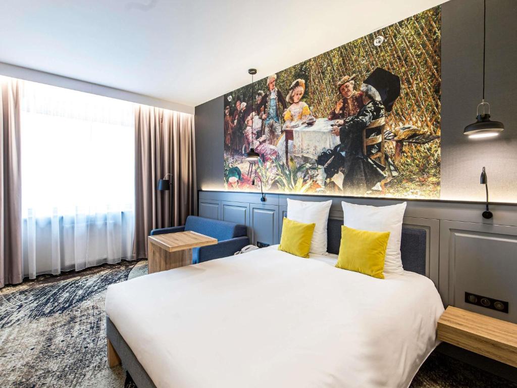 a hotel room with a bed and a painting on the wall at Mercure Wrocław Centrum in Wrocław