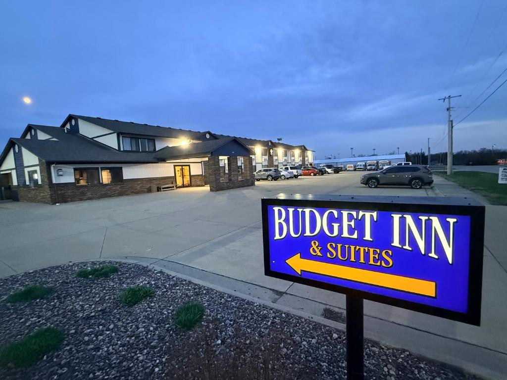 a blue sign in front of a house with a building at Budget inn & Suites in De Witt