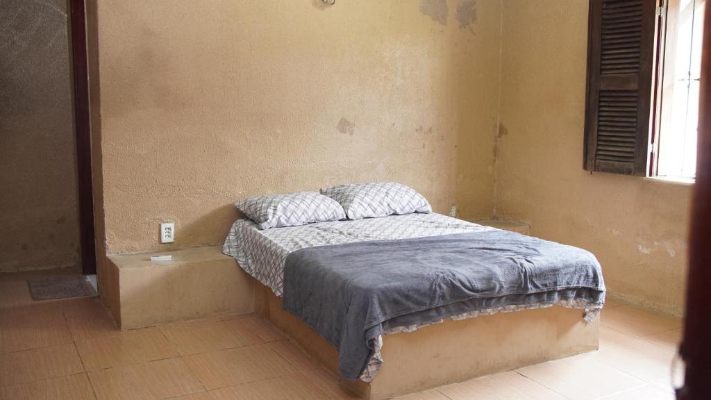 a bedroom with a bed with a blue blanket on it at Sítio Resenha in Caucaia
