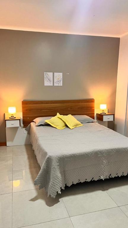 a bedroom with a bed with two yellow pillows on it at Gris Urbano in Federación