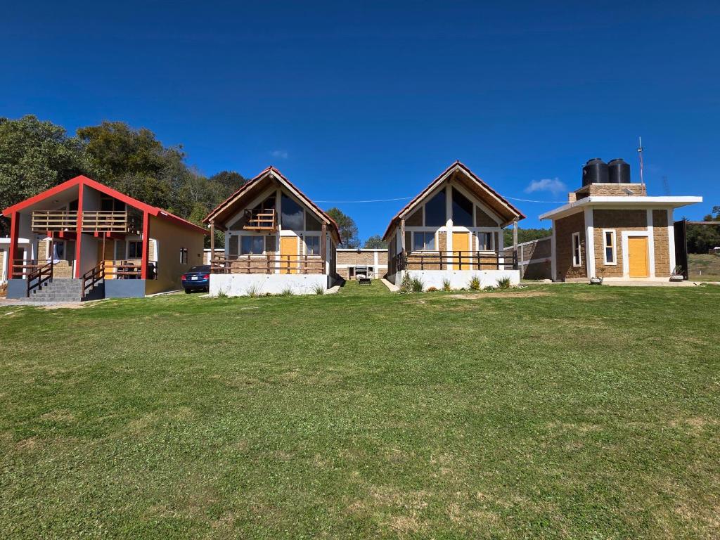 a group of houses on a grass field at Cabañas El Marqués Zacatlán con Starlink in Zacatlán