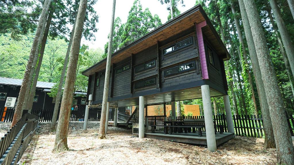 a building in the middle of some trees at Japanese Cottage Nagomiya seseragi in Gujo