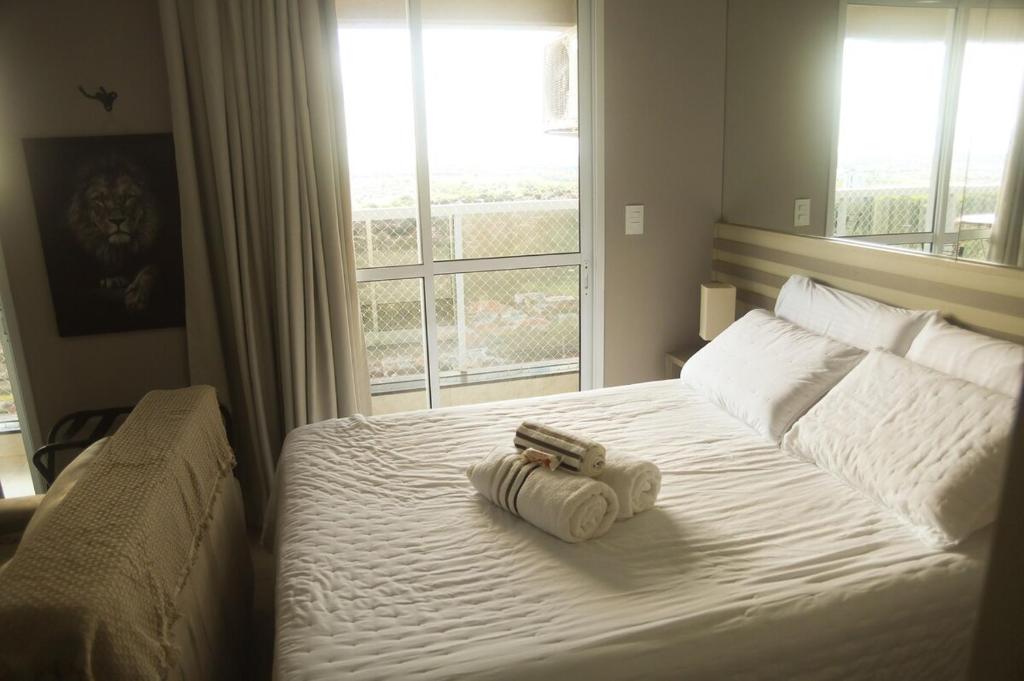 a bedroom with a bed with two towels on it at Studio Premium - Bairro Nova Yorque Araçatuba in Araçatuba