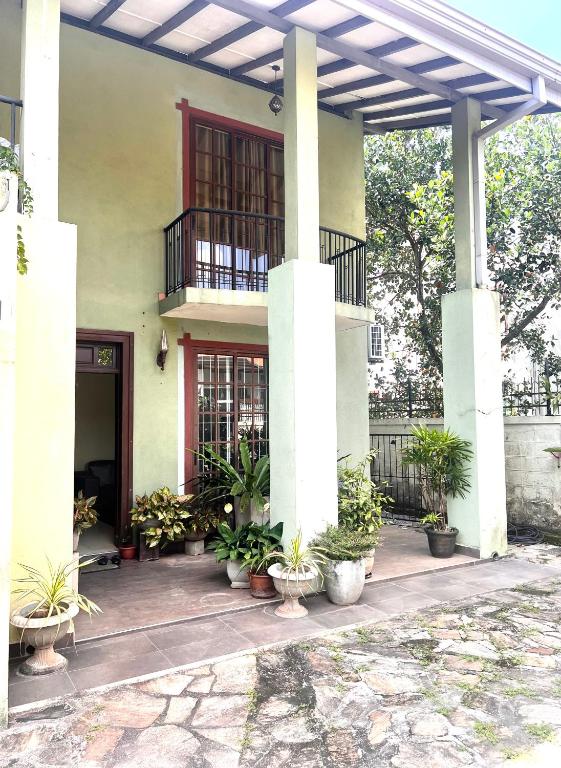 a building with potted plants in front of it at Airport home stay in Ekala