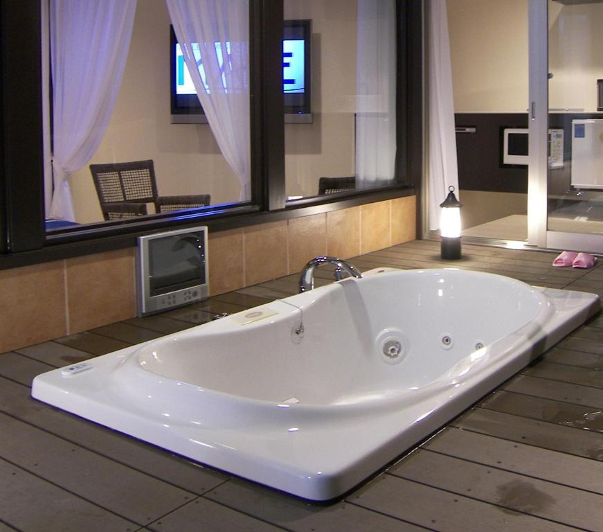 a large white tub in a bathroom with a tv at Hotel Mare - Vacation STAY 24956v in Kure