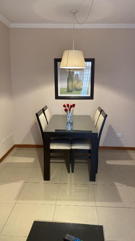 a dining room table with two chairs and a vase of flowers at Zárate Temporarios in Zárate
